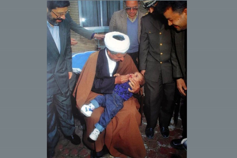 تصویر عکسی از رفسنجانی در حال ریشه‌کنی فلج اطفال